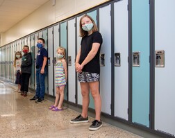 Students standing next to lockers