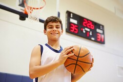 A high school student holding a basketball