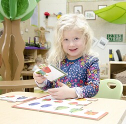 Girl smiling and playing with crafts in classroom