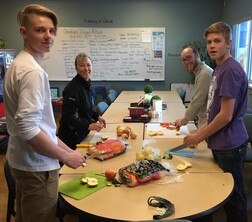 Two students and two teachers preparing healthy snacks
