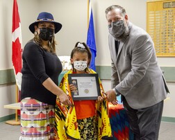 Student holding her award with a mask on
