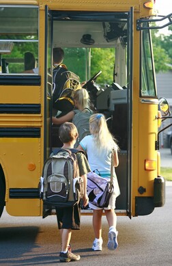 Middle school kids stepping in school bus